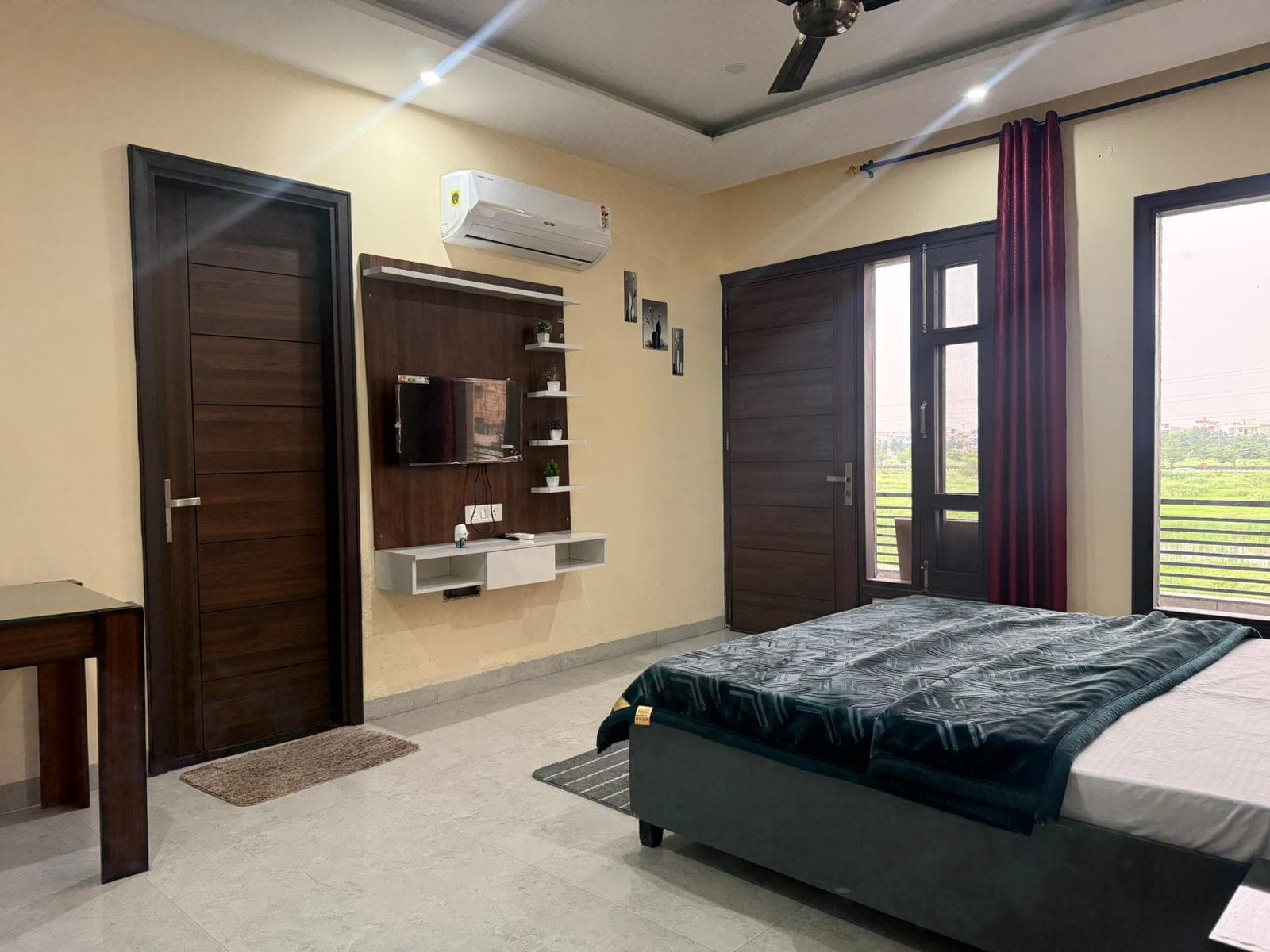 Air-conditioned bedroom with TV and balcony at Jastej House, Aerocity Mohali